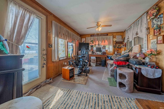 interior space with wooden walls, carpet, and ceiling fan