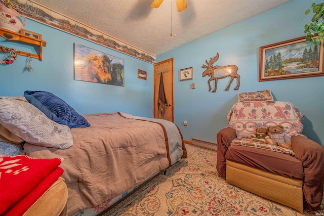 bedroom featuring baseboards, baseboard heating, a textured ceiling, and ceiling fan