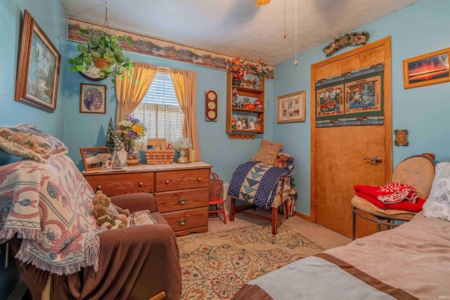 bedroom with light colored carpet, a ceiling fan, and a textured ceiling