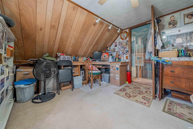 office space featuring track lighting, carpet, vaulted ceiling, a textured ceiling, and a ceiling fan