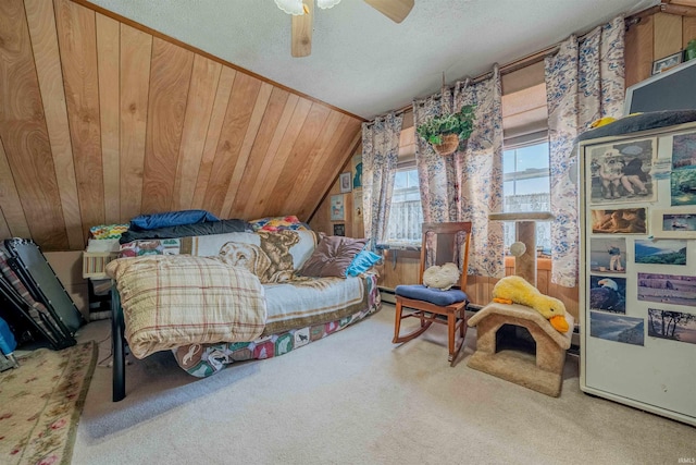 carpeted bedroom featuring a textured ceiling, wooden walls, ceiling fan, and vaulted ceiling