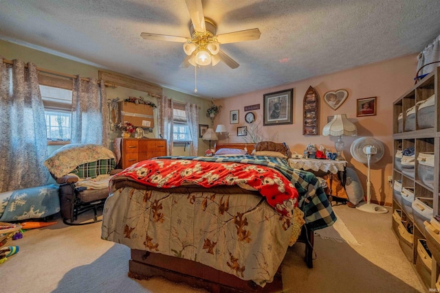 carpeted bedroom featuring multiple windows, a textured ceiling, and a ceiling fan