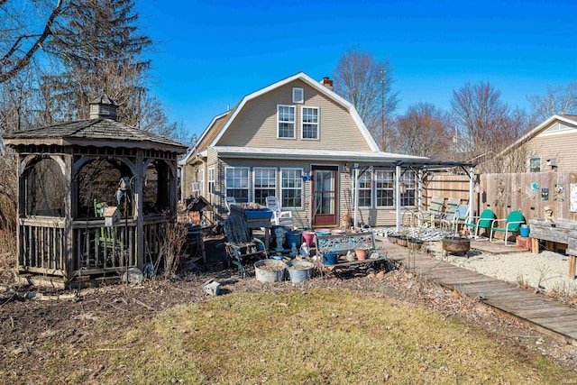 back of house featuring a gazebo, fence, and a gambrel roof