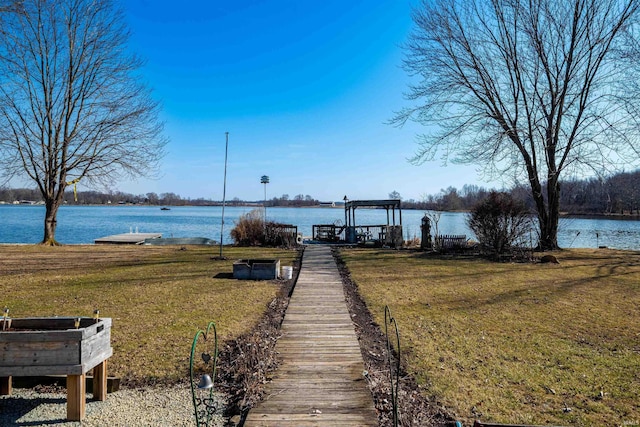 dock area with a yard, a water view, and boat lift