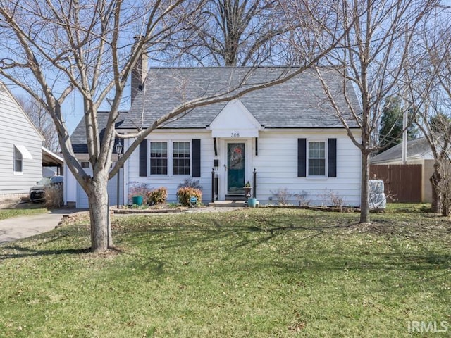 view of front of property with fence, roof with shingles, concrete driveway, a front yard, and a garage