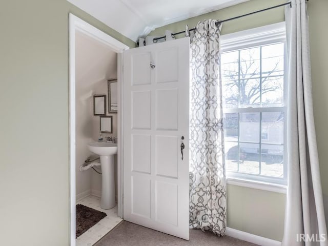 bathroom featuring lofted ceiling and baseboards