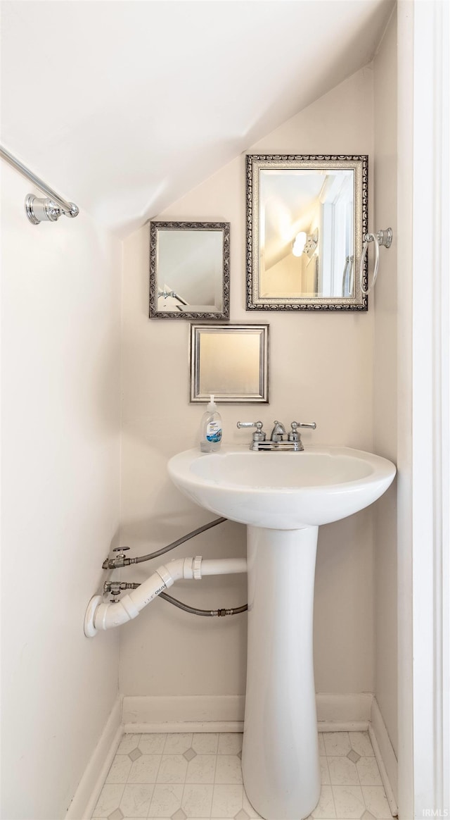 bathroom featuring vaulted ceiling and baseboards