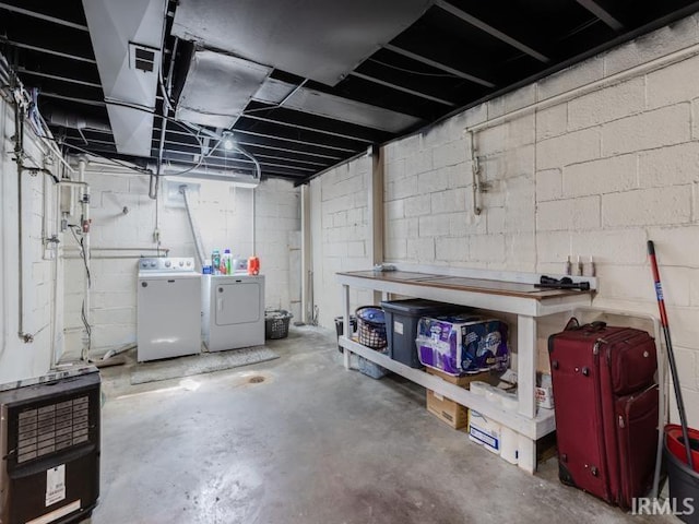 unfinished below grade area with heating unit, visible vents, and washer and clothes dryer