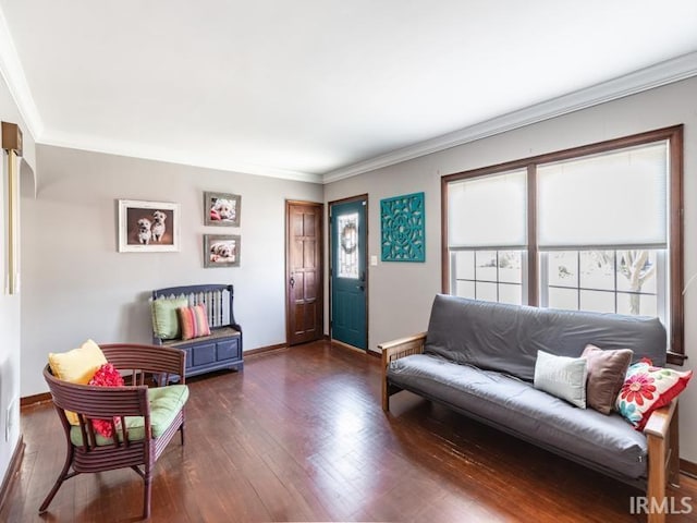 living area with baseboards, crown molding, and hardwood / wood-style flooring