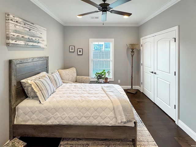 bedroom with visible vents, ornamental molding, a closet, baseboards, and dark wood-style flooring