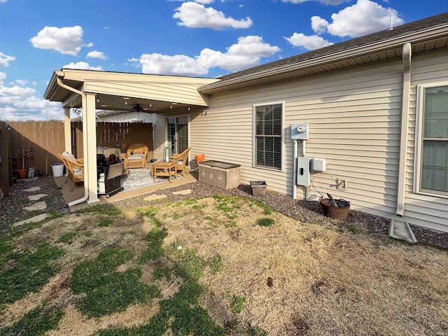 back of property with ceiling fan, a patio, and fence