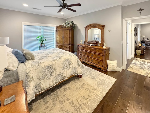 bedroom with dark wood finished floors, crown molding, visible vents, and ceiling fan