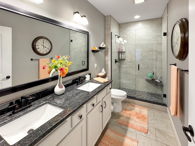 full bathroom featuring a sink, toilet, double vanity, and a shower stall