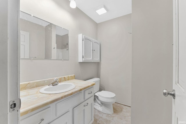 bathroom featuring toilet, vanity, and tile patterned flooring