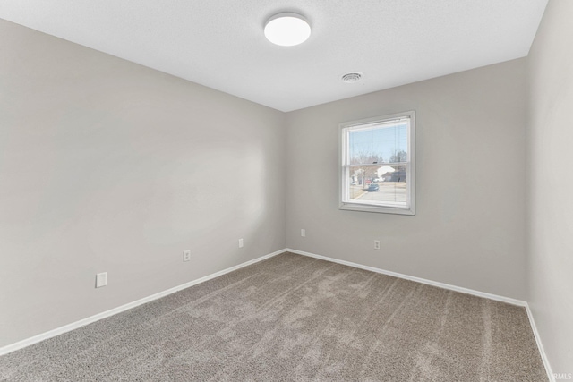 carpeted empty room with visible vents and baseboards