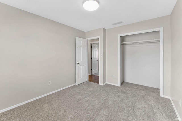 unfurnished bedroom featuring a closet, visible vents, baseboards, and carpet