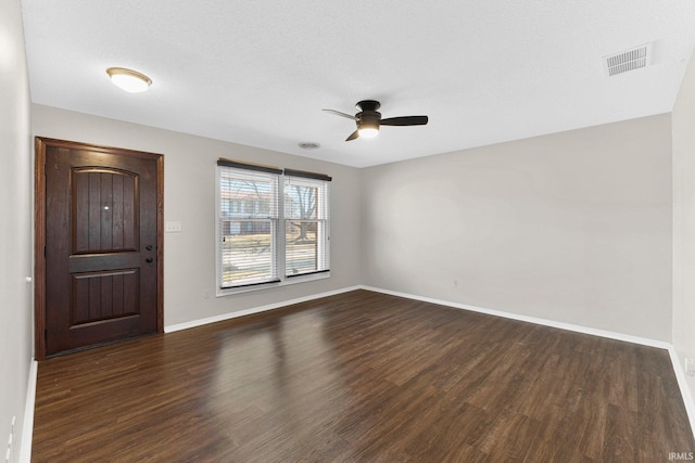 interior space with dark wood-style floors, visible vents, a ceiling fan, and baseboards