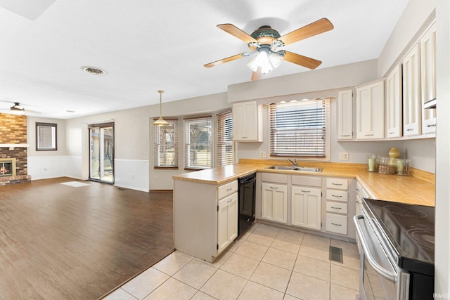 kitchen with a peninsula, stainless steel electric range, light countertops, dishwasher, and open floor plan