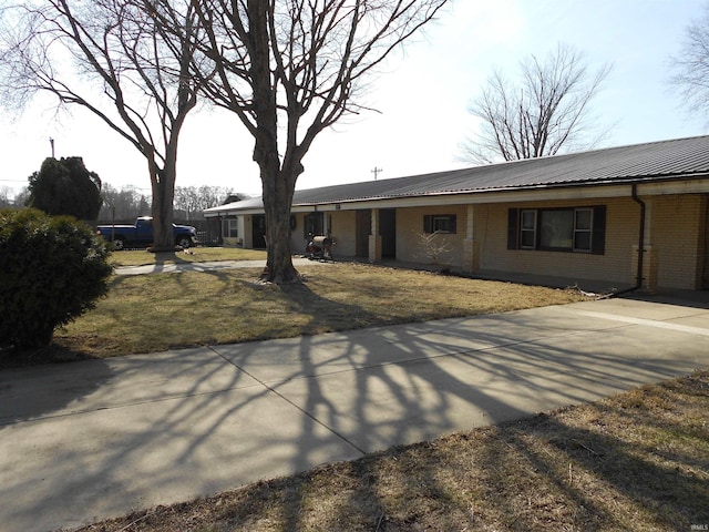 view of front of home with metal roof and brick siding