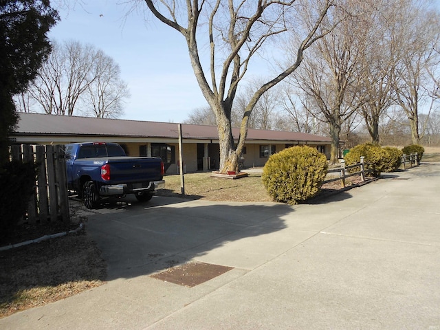 ranch-style house featuring a carport, driveway, and fence