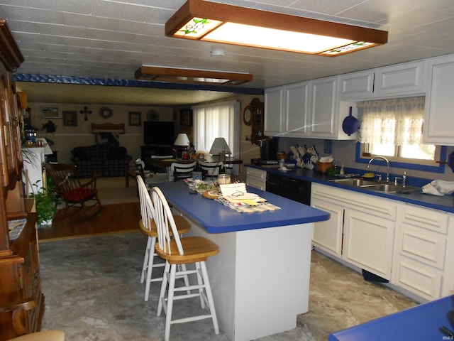 kitchen featuring a sink, a kitchen island, dark countertops, black dishwasher, and white cabinets