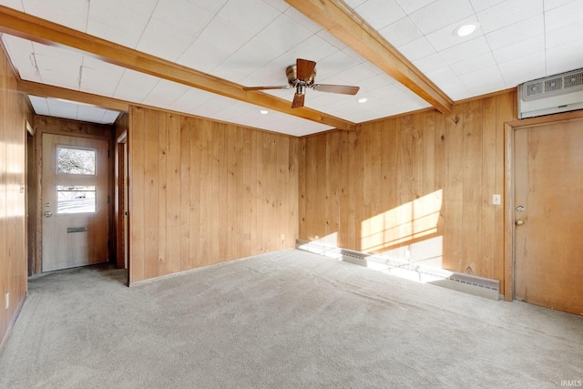 empty room featuring beam ceiling, wooden walls, a wall mounted AC, and carpet floors