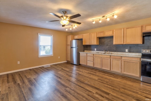 kitchen featuring dark wood finished floors, a sink, light brown cabinetry, light countertops, and stainless steel appliances