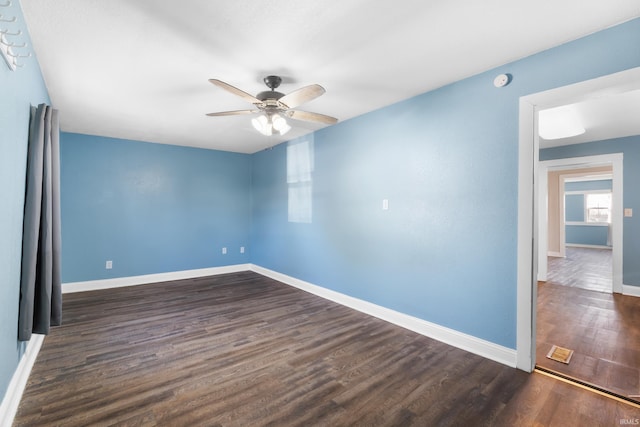 unfurnished room with dark wood-type flooring, baseboards, and ceiling fan