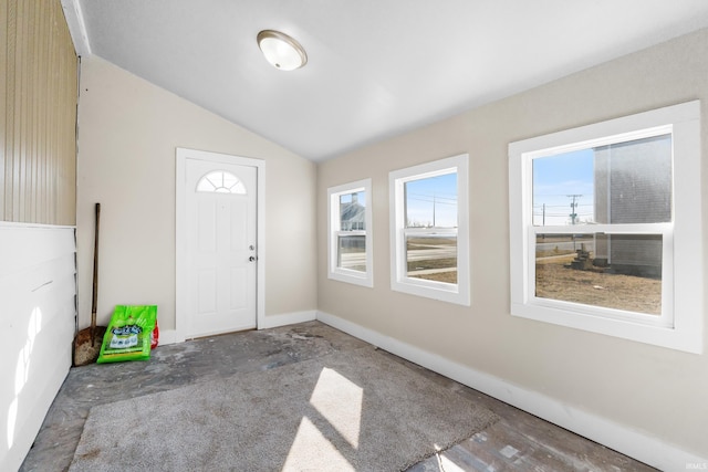 foyer entrance featuring baseboards and lofted ceiling