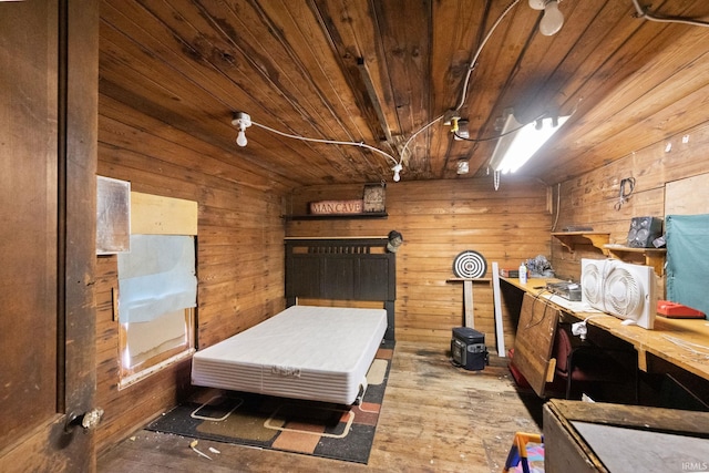 bedroom featuring wooden walls, wooden ceiling, and wood finished floors