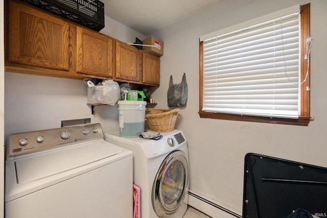 clothes washing area featuring cabinet space, a baseboard radiator, and washer and clothes dryer