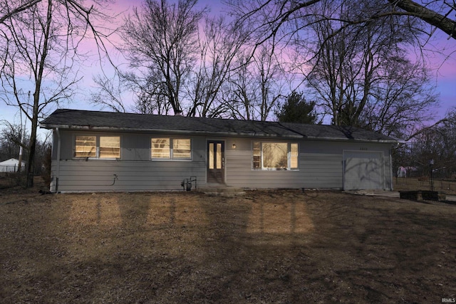 ranch-style house featuring a garage and dirt driveway