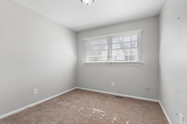 empty room featuring carpet, visible vents, and baseboards