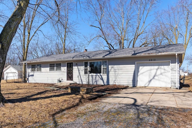 ranch-style house featuring a chimney, concrete driveway, and an attached garage