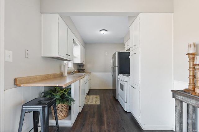 kitchen with dark wood finished floors, light countertops, white gas range oven, white cabinetry, and a sink