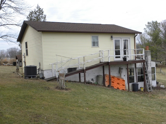 rear view of property featuring central air condition unit, stairway, a yard, and roof with shingles