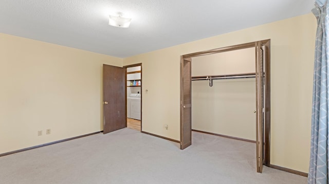 unfurnished bedroom featuring baseboards, carpet floors, washer / dryer, and a closet