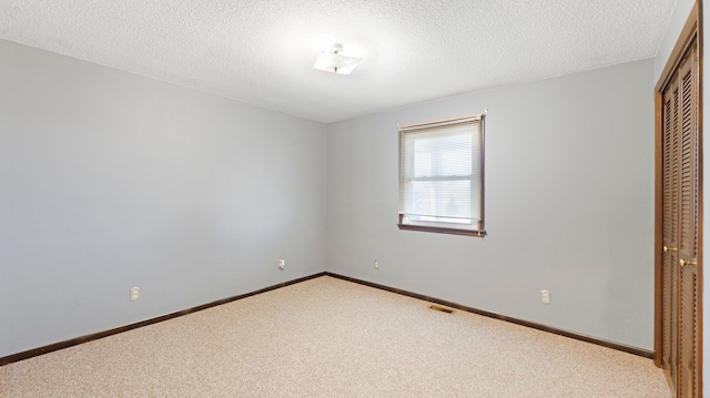 unfurnished bedroom with visible vents, baseboards, a closet, and carpet flooring