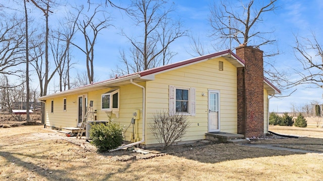 view of front of house with central AC unit and a chimney