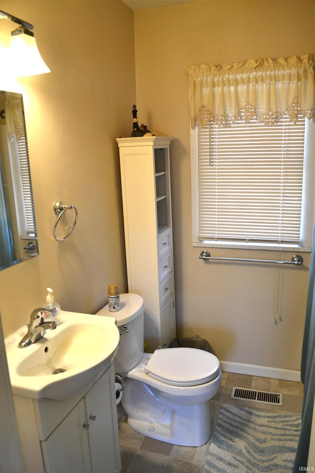 bathroom with tile patterned flooring, visible vents, baseboards, toilet, and vanity