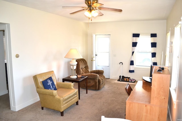 sitting room featuring baseboards, carpet, and a ceiling fan