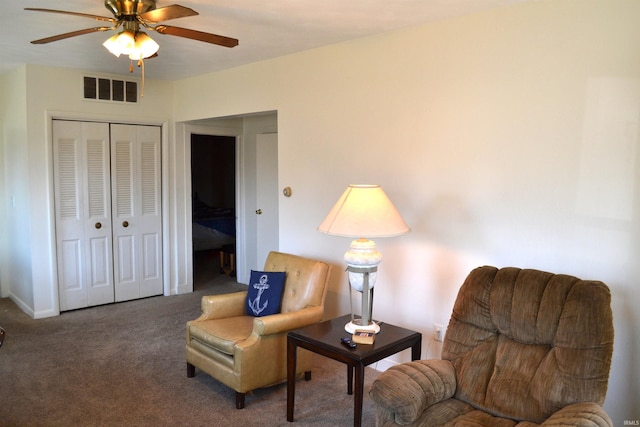 living area with visible vents, carpet floors, and ceiling fan