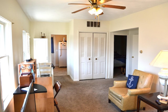 home office with baseboards, visible vents, carpet floors, and ceiling fan