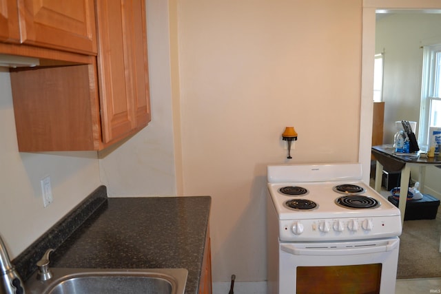 kitchen featuring a sink, dark countertops, and electric stove