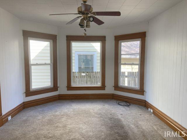 empty room with baseboards, a ceiling fan, and carpet flooring