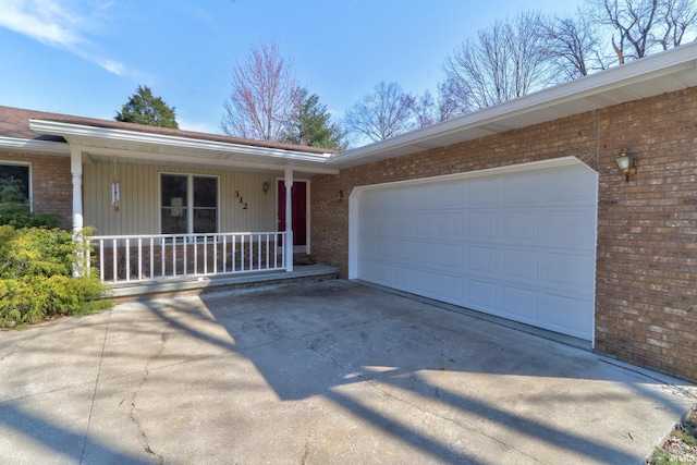 ranch-style home with a porch, driveway, an attached garage, and brick siding