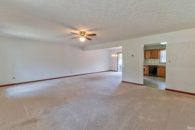 unfurnished room with baseboards, light carpet, a textured ceiling, and ceiling fan with notable chandelier