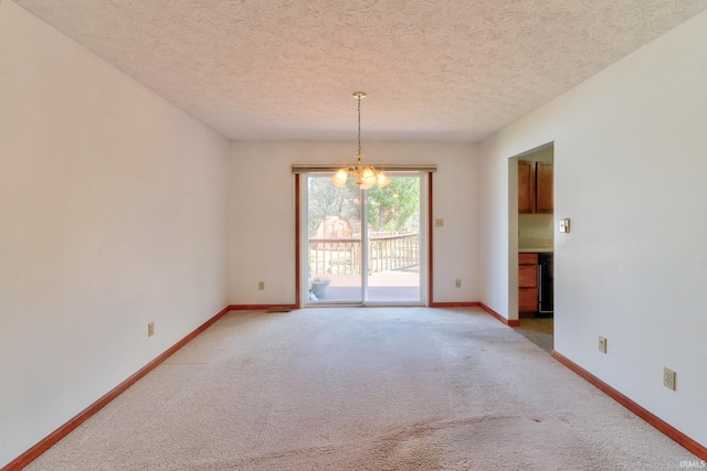 spare room with baseboards, a textured ceiling, light carpet, and a chandelier