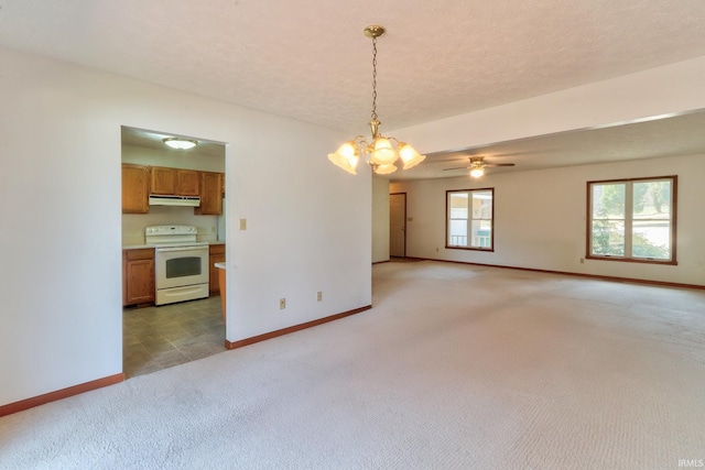 unfurnished room featuring light carpet, ceiling fan with notable chandelier, a textured ceiling, and baseboards