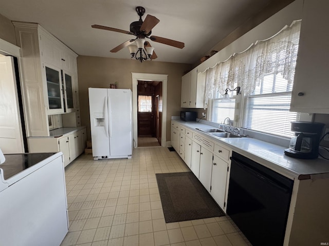 kitchen with white appliances, white cabinetry, and a sink